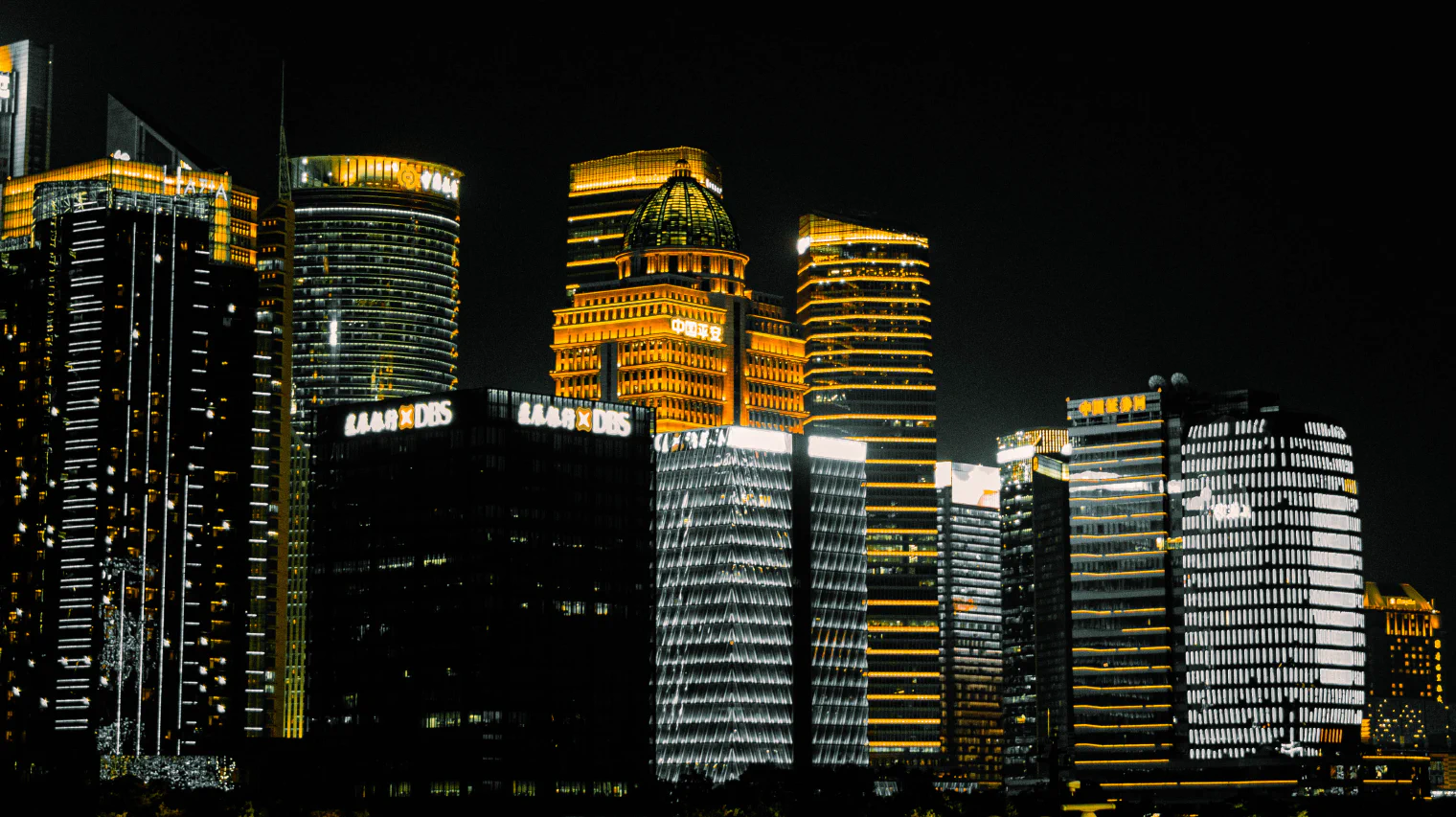 黑金色调的陆家嘴楼群：深黑夜空下，金色灯带与冷白灯光勾勒出建筑轮廓。